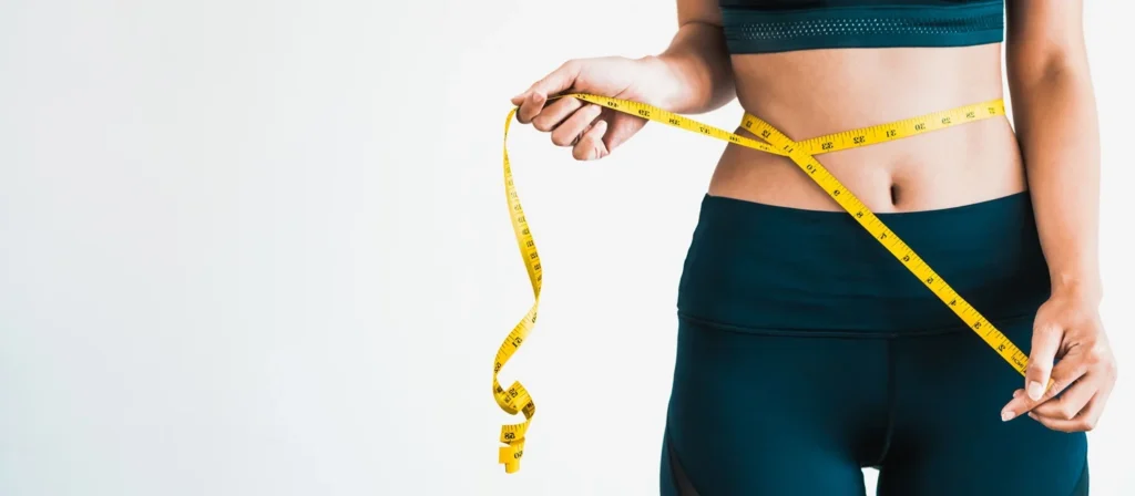 a woman measuring her waist