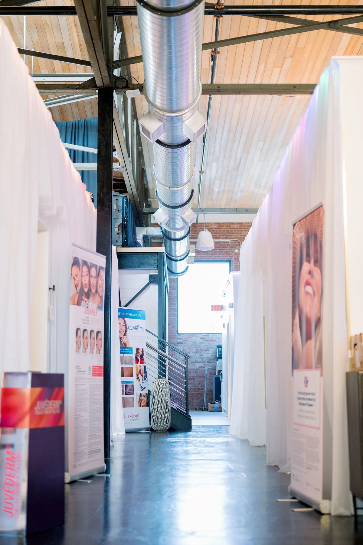 a long hallway with metal pipes and a staircase