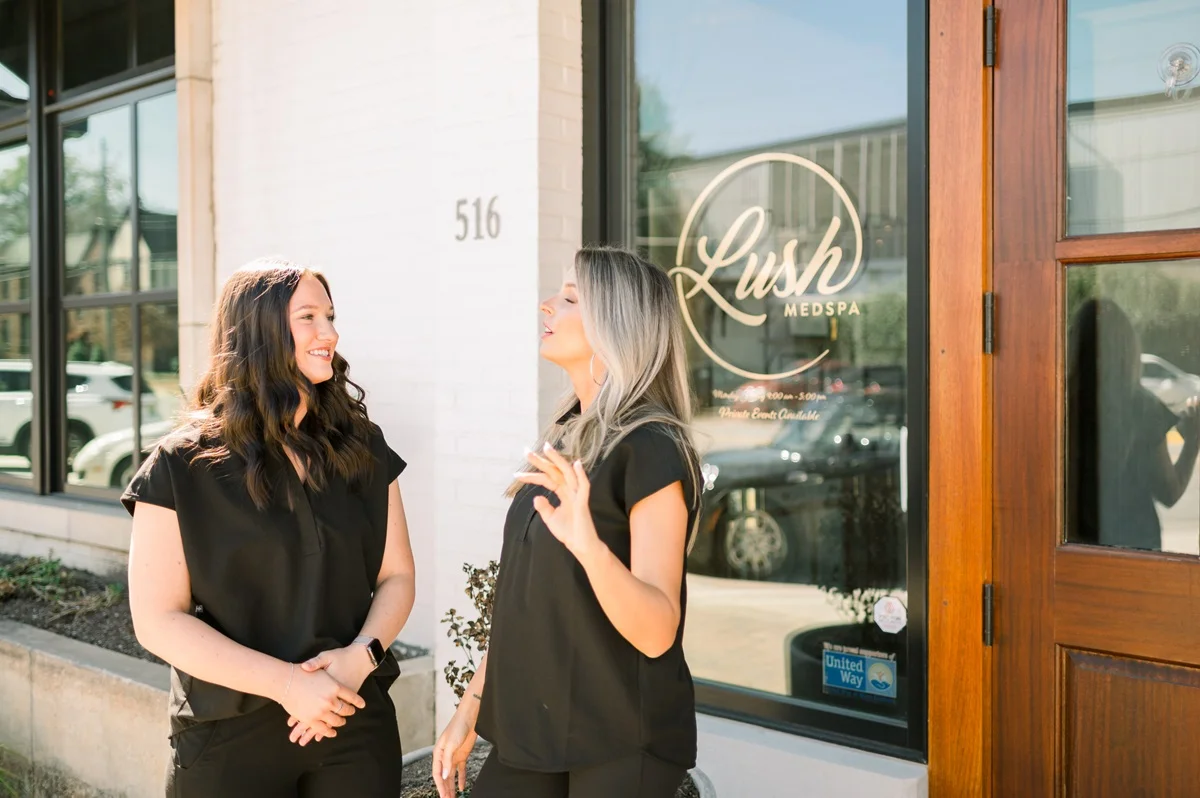 two women standing outside a store